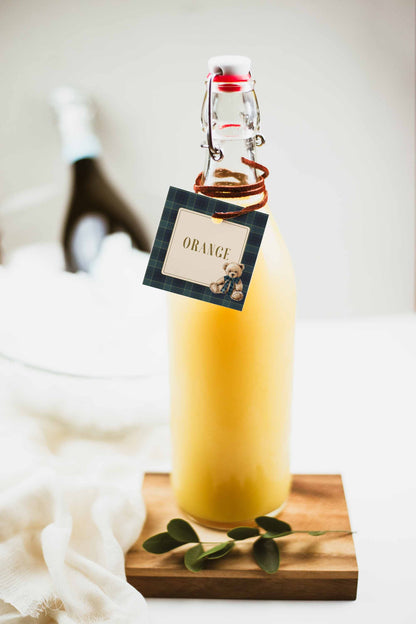 Bottle of orange juice with a tag on a wooden coaster