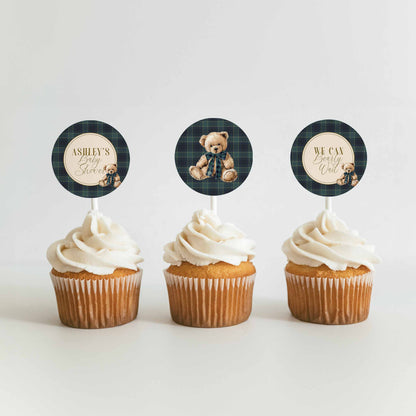Three cupcakes with plaid bear-themed toppers on a white background