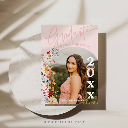 Graduation invitation card with bright colorful floral design and photo of a young woman on a light background